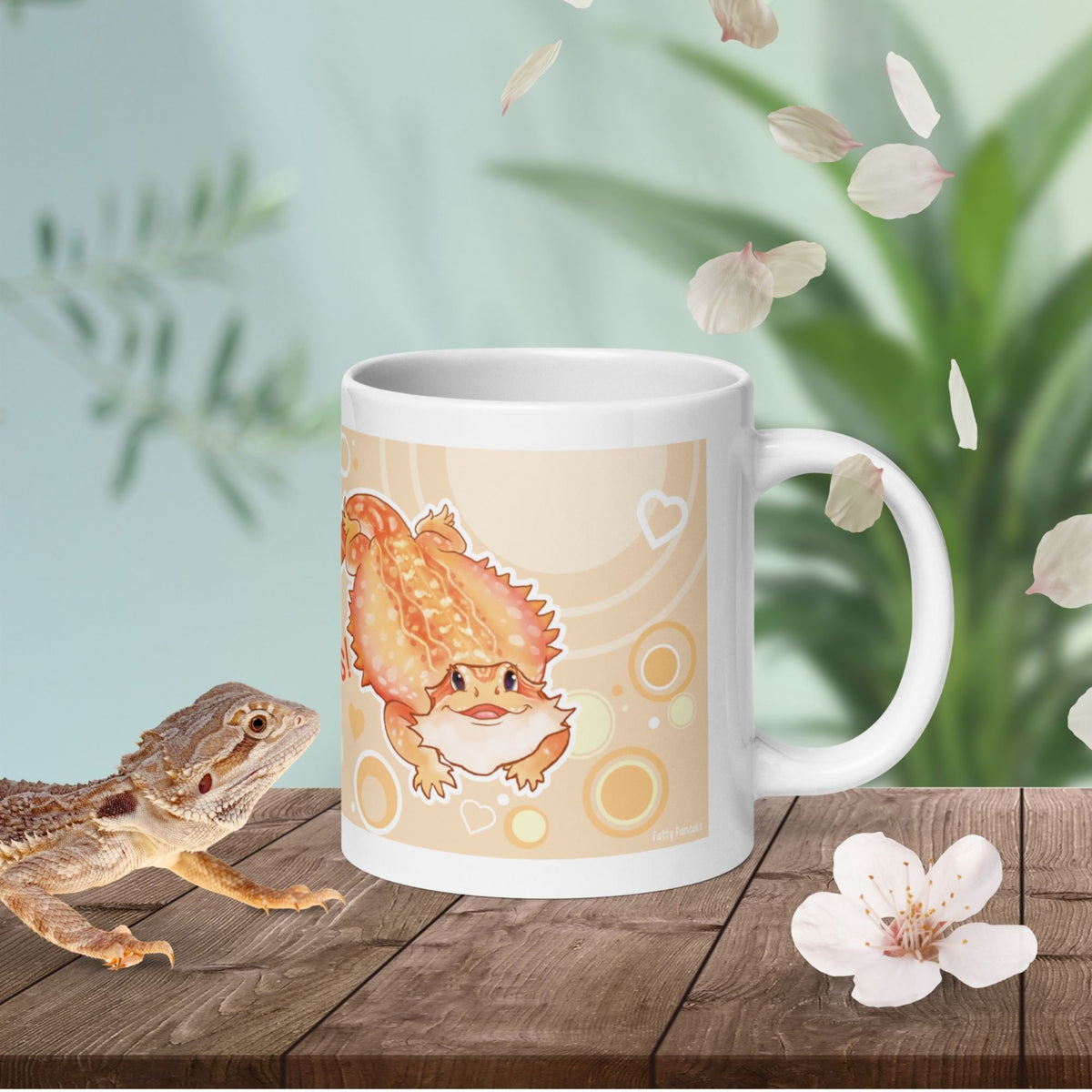 A white ceramic mug featuring a cartoon illustration of an orange bearded dragon on a light tan background with circular patterns and small white hearts. The mug has a standard handle and a smooth, glossy finish.