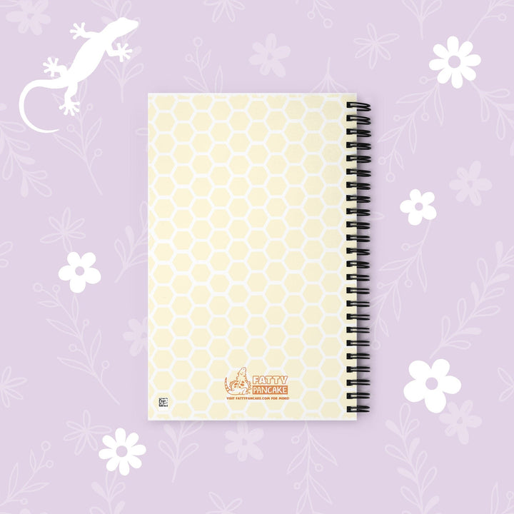 A spiral-bound notebook with a pale yellow and white honeycomb pattern cover, featuring the &