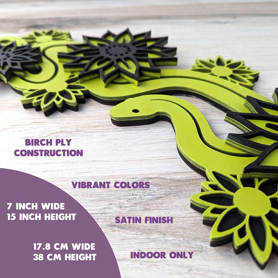 Shows side view of snake with flowers laser cut wall art in key lime and black color. Text reads: Measures 7 inches wide, and 15 inches high. Made of birch ply for solid construction, rich vibrant colors, a satin finish. Recommended for Indoors only.