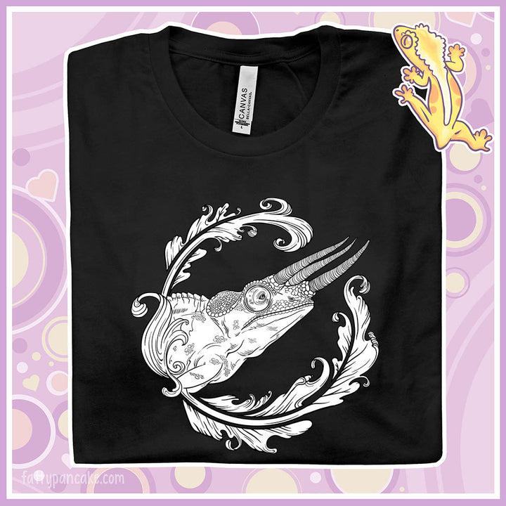 A folded black crew neck tee with a black and white design of a jackson's chameleon and a round elegant flourish surrounding the reptile.