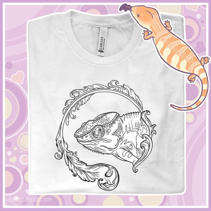 A folded white crew neck tee of a black and white panther chameleon surrounded by a beautiful flourish design.