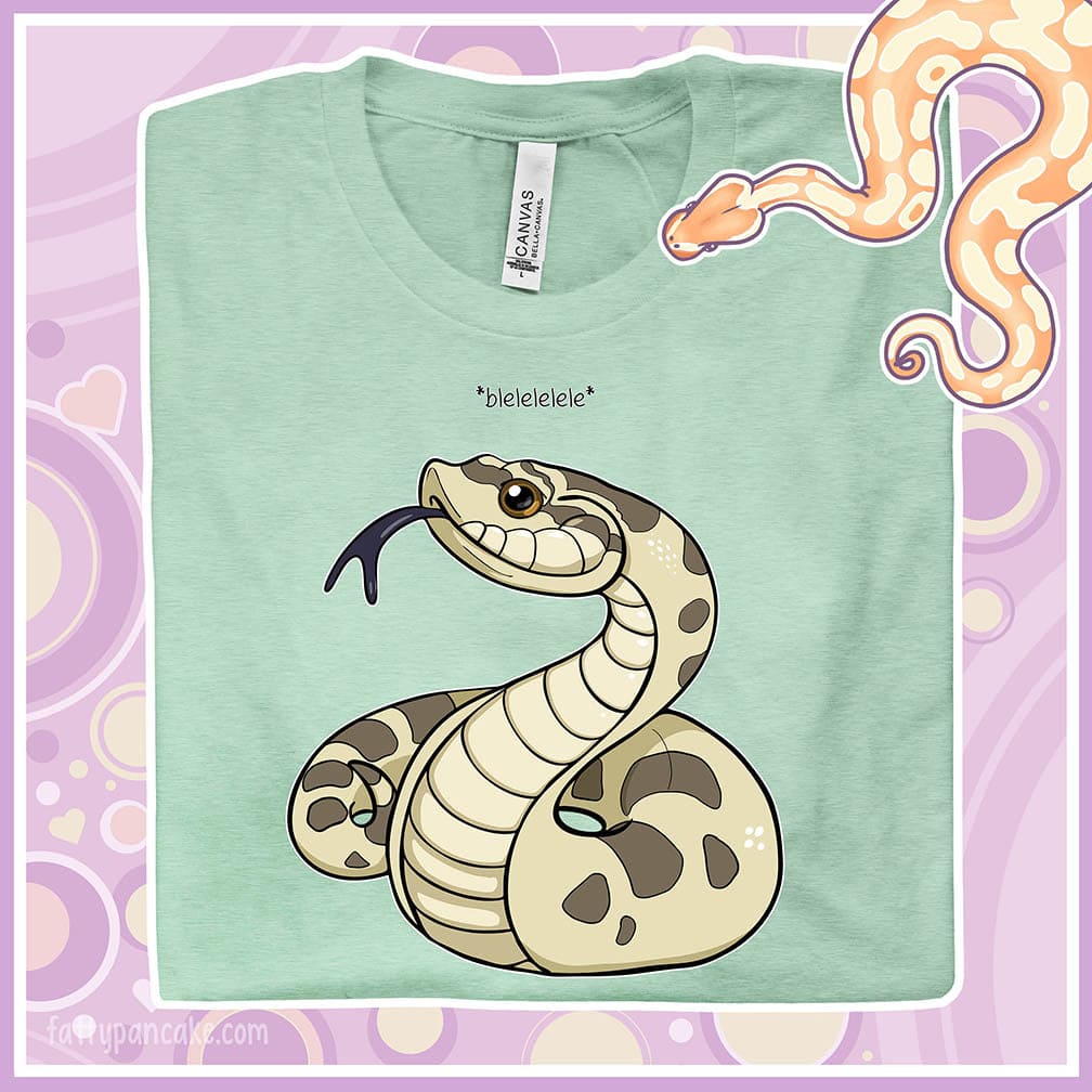 A folded heather prism mint colored crew neck tee with a simple cartoony silly hognose flicking out it's tongue and saying "blelele".