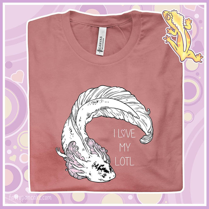 A folded mauve crew neck tee with a white axolotl with black speckles on it's nose and pink gills that have very delicate line art on it. There is text that reads I love my lotl.