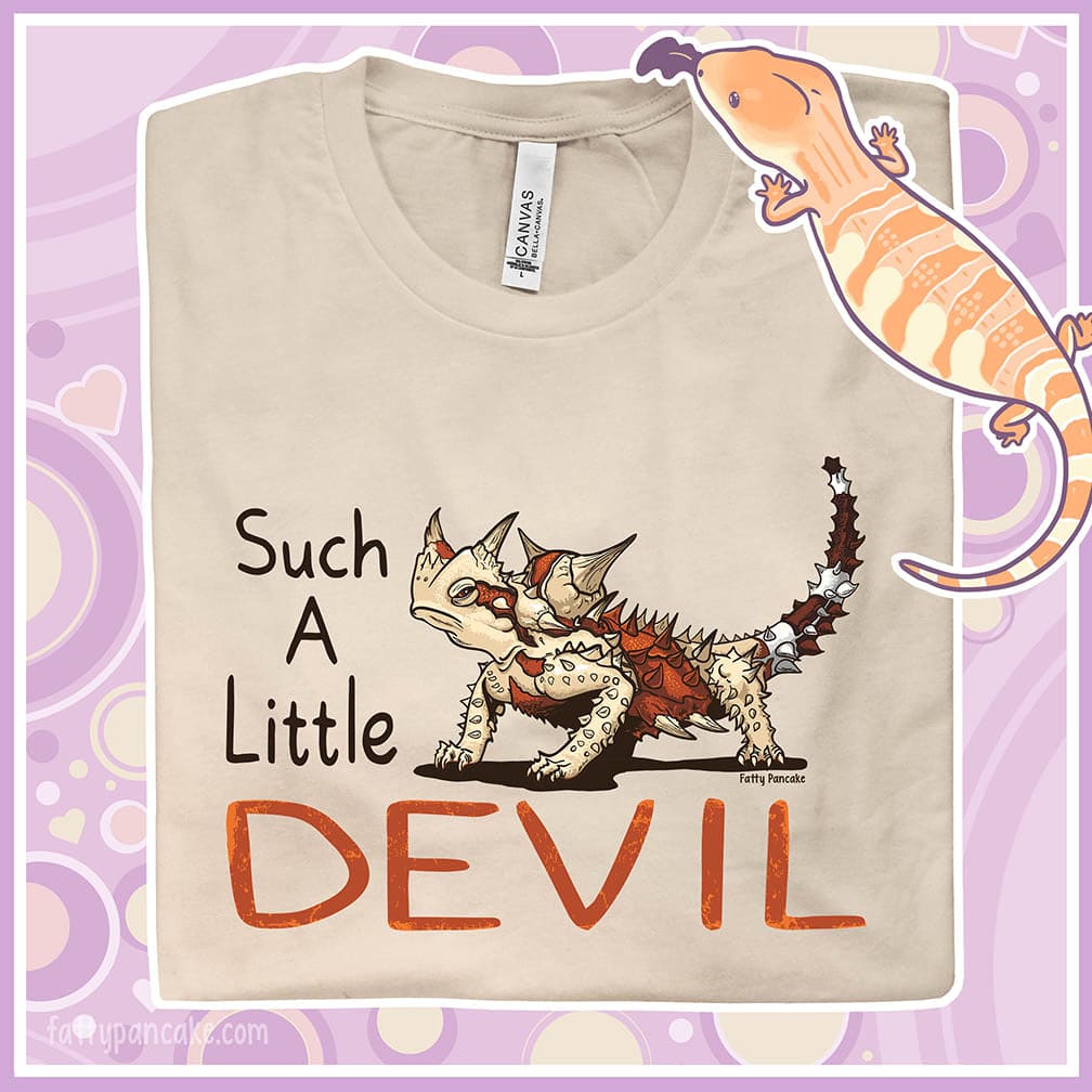 A folded soft cream colored crew neck tee with a thorny devil lizard on it with text that reads: "Such a little Devil".