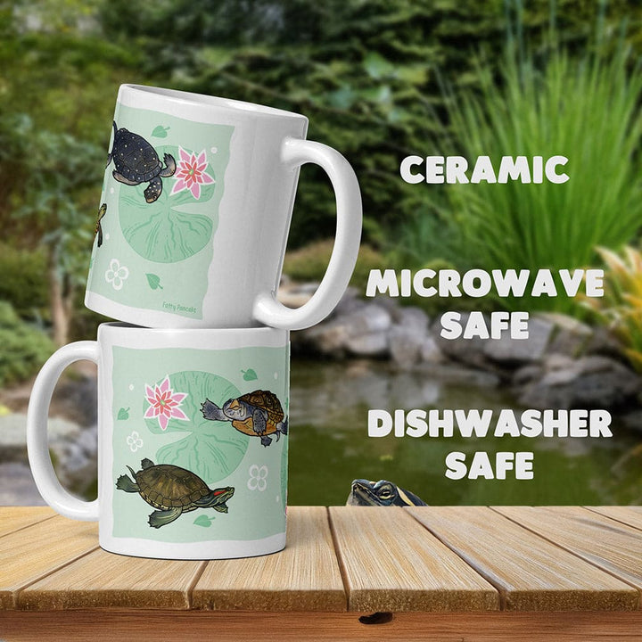 Two ceramic mugs with turtle designs on a wooden surface with a natural background.