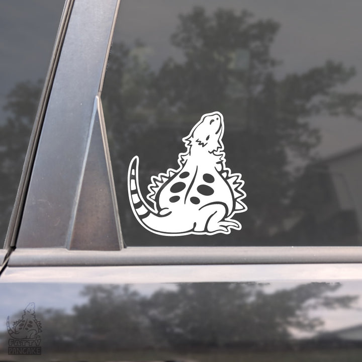 A white cartoon Fatty Pancake bearded dragon decal adhered to a car window.