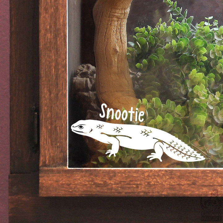 A white vinyl decal of a Gidgee Skink lizard with the name &