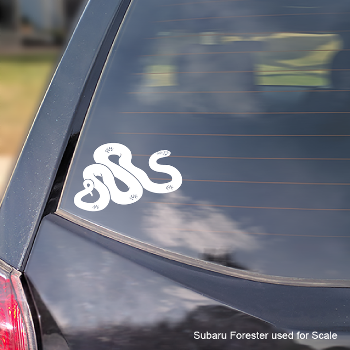 A white vinyl decal of the Mexican Black Snake applied to the rear window of a Subaru Forester. 