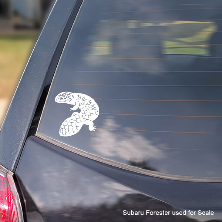 A white vinyl decal of a Shingleback skink applied to the rear window of a dark car, shown for scale with a text overlay.