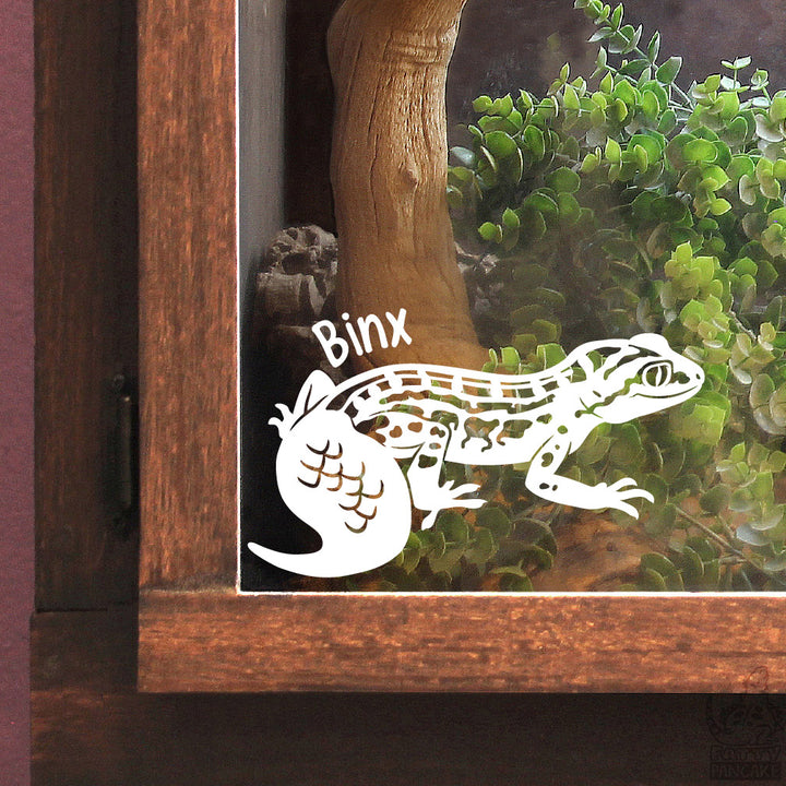 A white vinyl decal of a gecko with the name &