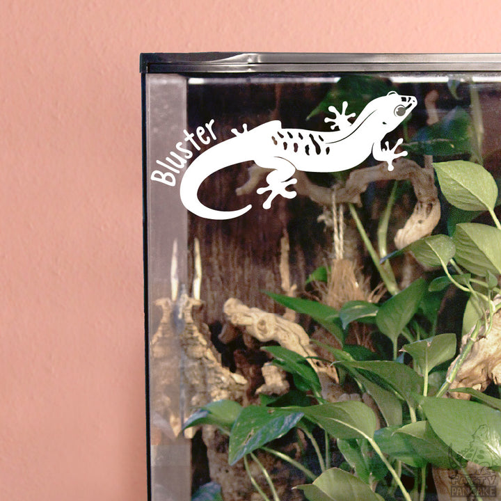 White vinyl decal of a Giant Day Gecko applied to a glass terrarium with plants growing inside.