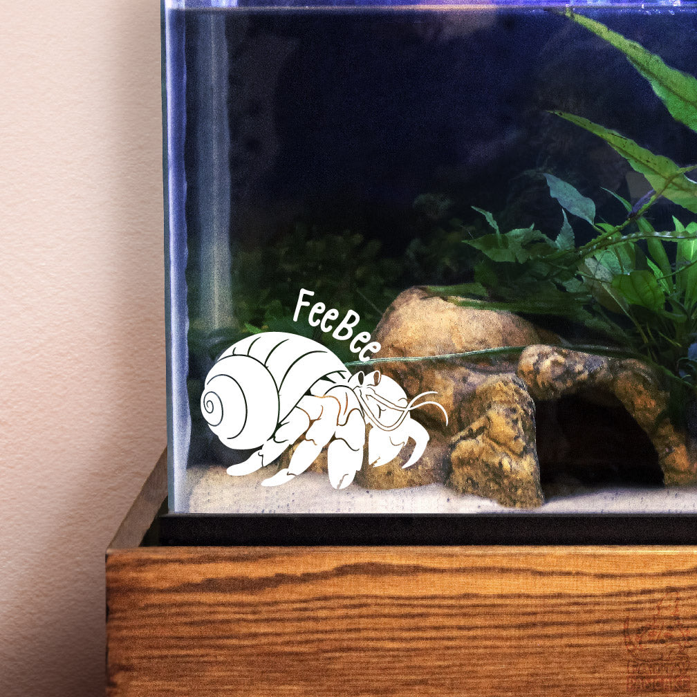 Aquarium with a white decal of a hermit crab and decorative elements.