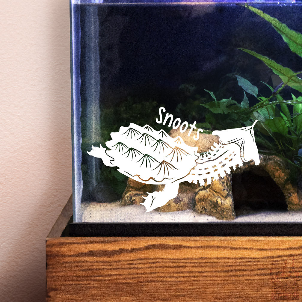 Decorative white vinyl decal of a Mata Mata Turtle design with the name Snoots over the graphic. The decal is placed water enclosure.