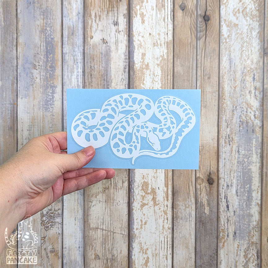 A hand holds a rectangular light blue paper featuring a white Children&