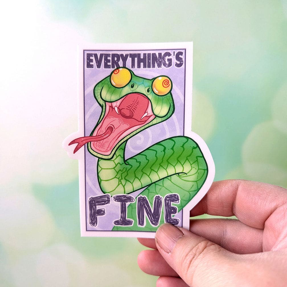 Green cartoon boomslang snake sticker being held by human hand for scale.