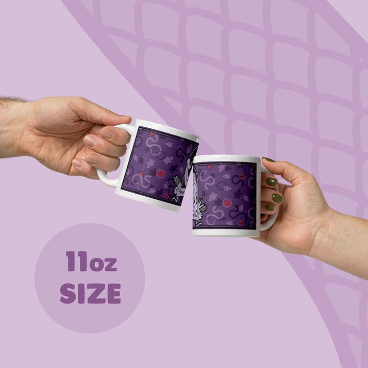 Two hands holding white ceramic mugs with a purple apple and snake pattern, clinking them together on a light purple graphic background with &