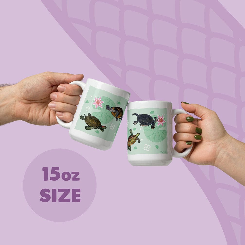 Two white ceramic mugs with an 15oz size capacity, each featuring a light green background decorated with illustrations of fresh water turtles and pink water lilies. The mugs are held up, showcasing the detailed aquatic animal artwork.