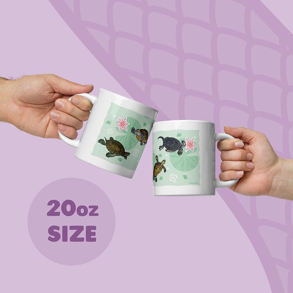 Two white ceramic mugs with an 20oz size capacity, each featuring a light green background decorated with illustrations of fresh water turtles and pink water lilies. The mugs are held up, showcasing the detailed aquatic animal artwork.