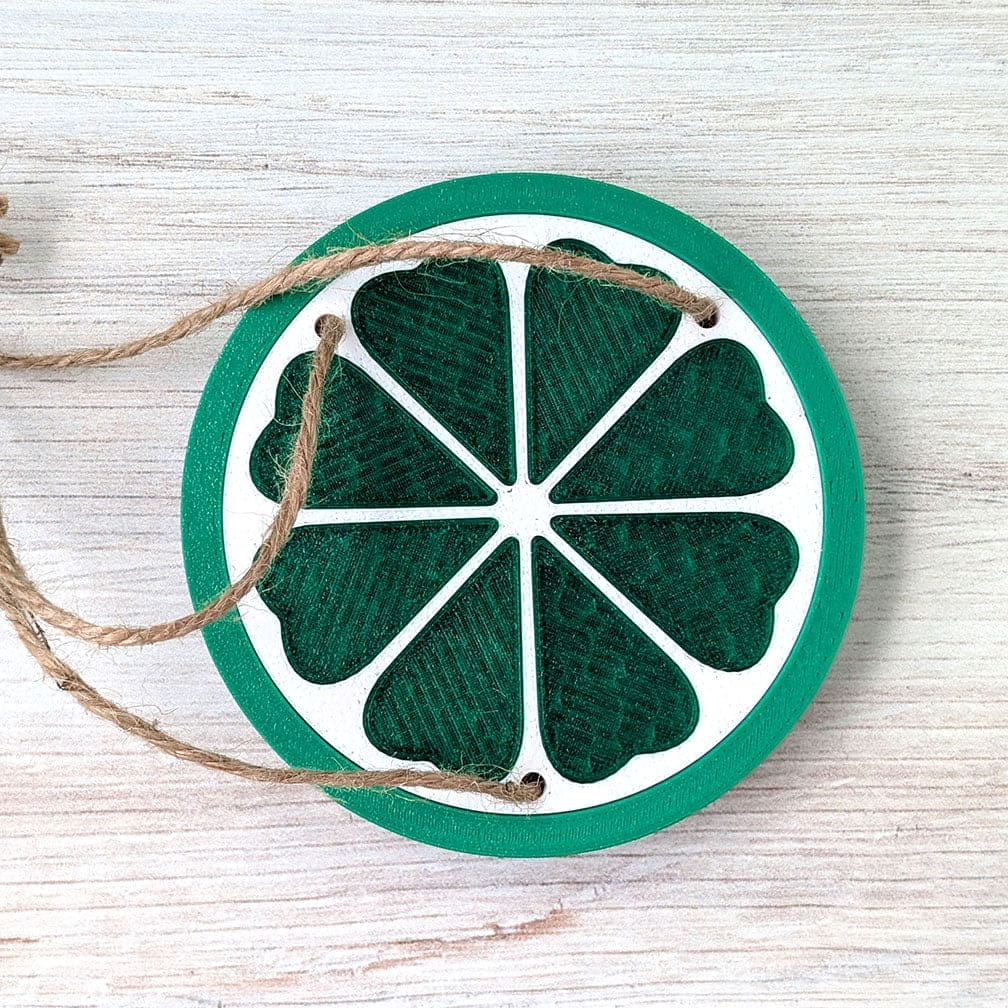 Decorative lime slice ornament with string on a wooden surface.