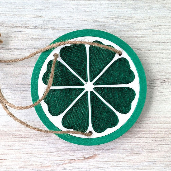 Decorative lime slice ornament with string on a wooden surface.