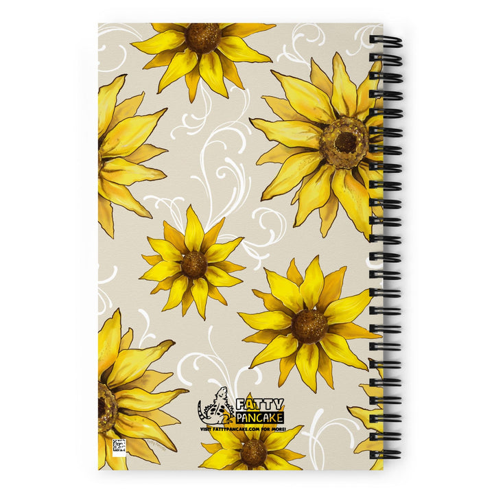 A spiral-bound notebook with a beige cover featuring yellow sunflower designs, displayed on a bright white background.