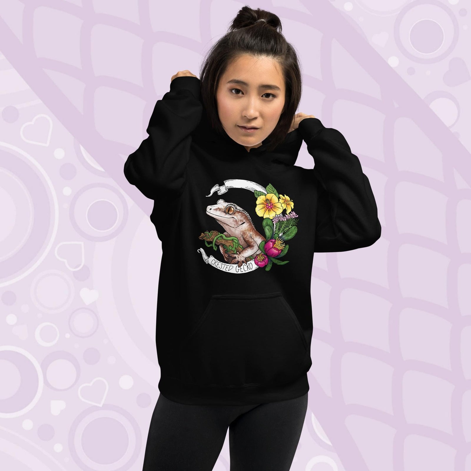 Black hoodie with a graphic of a crested gecko with flowers and the text "Crested Gecko".