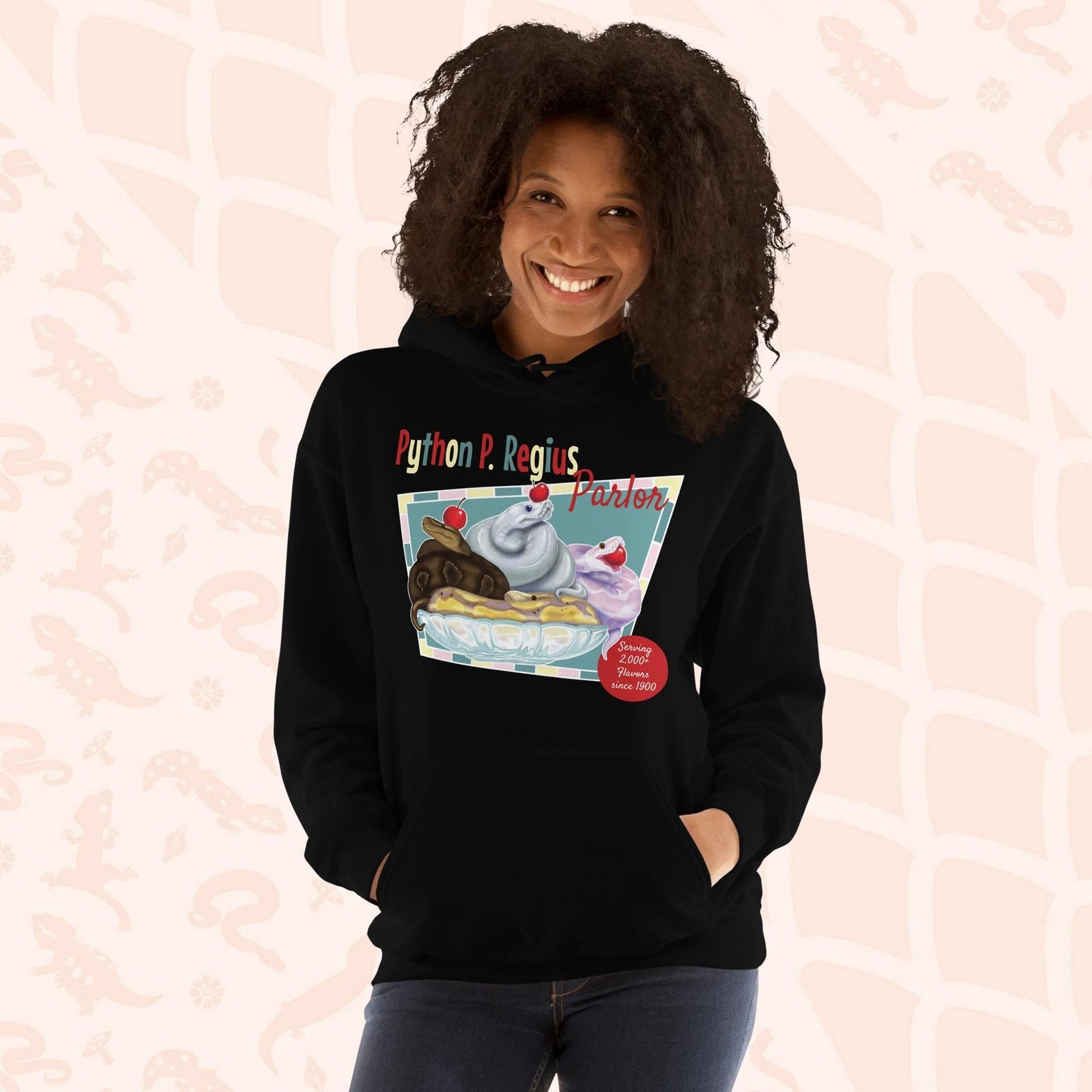 A black hoodie with a retro-style graphic of a sundae with three ball pythons on top. The graphic says "Python P. Regius Parlor" and "Serving 2,000+ flavors since 1990".