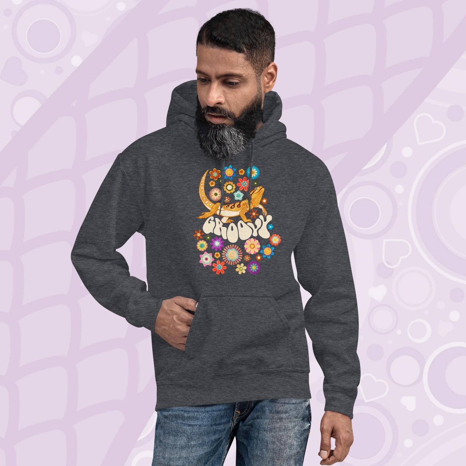 A dark grey hooded sweatshirt with a graphic of a bearded dragon with the word "Groovy" in a retro font surrounded by colorful flowers in a 70's inspired theme. The hoodie has a front pocket.