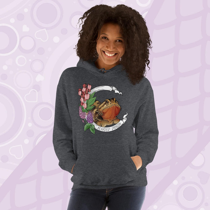 A woman wearing a dark grey hooded sweatshirt with a graphic of a bearded dragon with pink flowers and the text "Bearded Dragon".