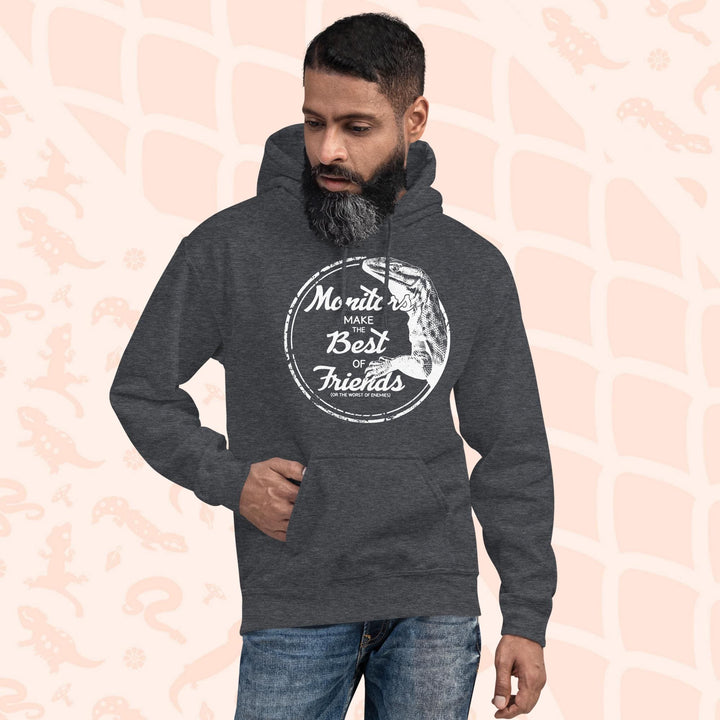 Man wearing a dark grey hoodie with a white graphic of an ackie monitor lizard and the text "Monitors Make the Best of Friends" in a circle.