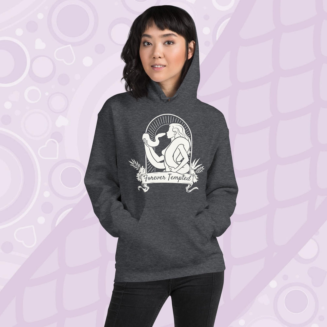 Woman wearing a grey hoodie with a white graphic of a silhouetted woman with a snake wrapped around her. Her hand holds up the snakes head and they are staring at each other. The graphic is in an arch with the text "Forever Tempted" on a banner below.