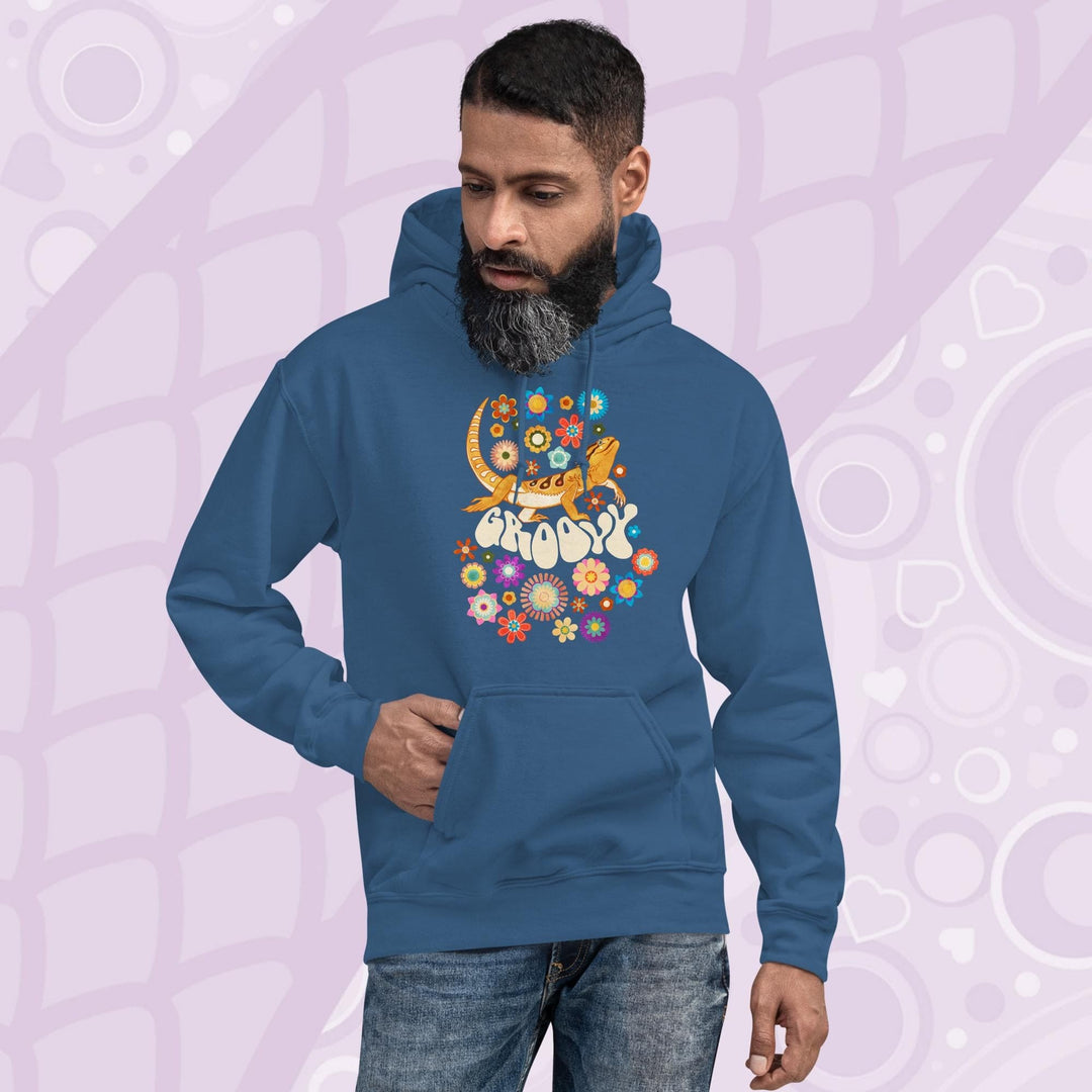 A blue hooded sweatshirt with a graphic of a bearded dragon with the word "Groovy" in a retro font surrounded by colorful flowers in a 70's inspired theme. The hoodie has a front pocket.