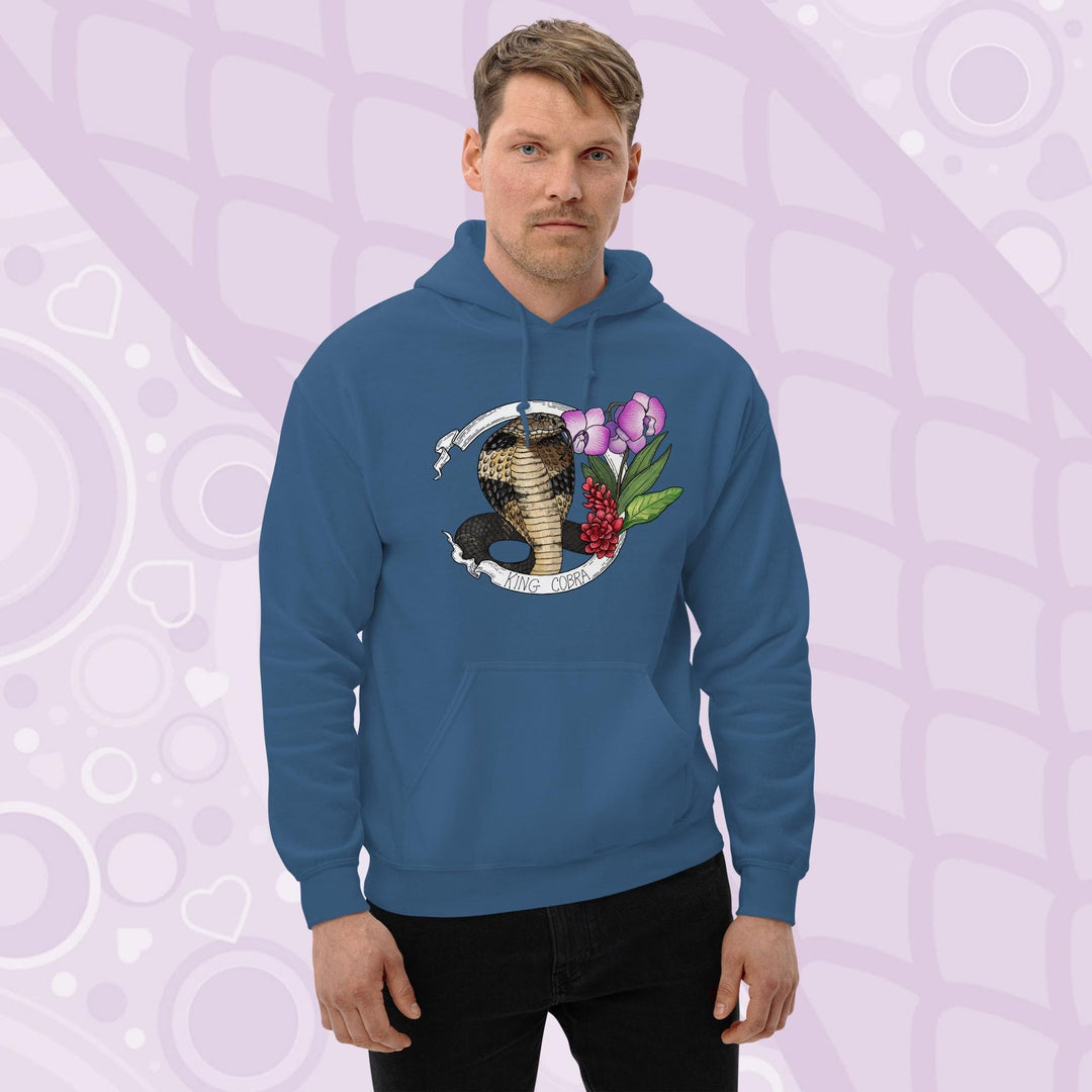 A man wearing a neutral blue hooded sweatshirt with a graphic of a king cobra with pink orchids  and smaller red flowers on the right side of the design. The text "KING COBRA" is printed below the snake. The hoodie has a front pocket.