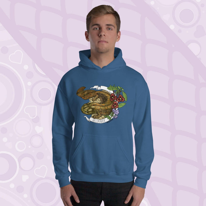 A man wearing a neutral blue hoodie featuring a detailed illustration of a salamander with the text "HELLBENDER" in white. The design includes floral elements in red, green, and purple. The hoodie has a front pocket and a hood.