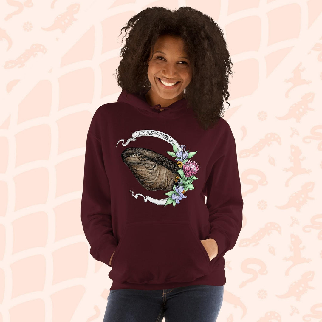 A dark red maroon hooded sweatshirt with a graphic of a black-throated monitor lizard with flowers and the text "Black-throated Monitor" on a white banner.