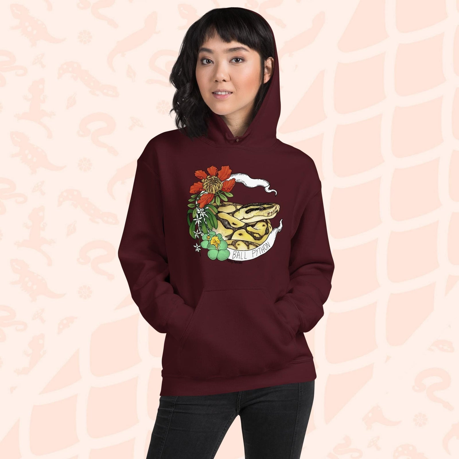 A deep red maroon hoodie with a graphic of a ball python snake with flowers and the text "Ball Python" on a white banner.