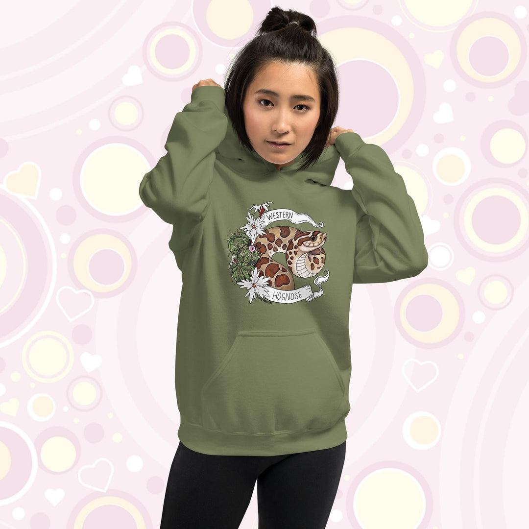 A woman wearing an olive green colored hoodie with a line art with color hognose snake surrounded by a white banner with text that reads "Western Hognose". Cactus and white flowers are on the left side of the design.