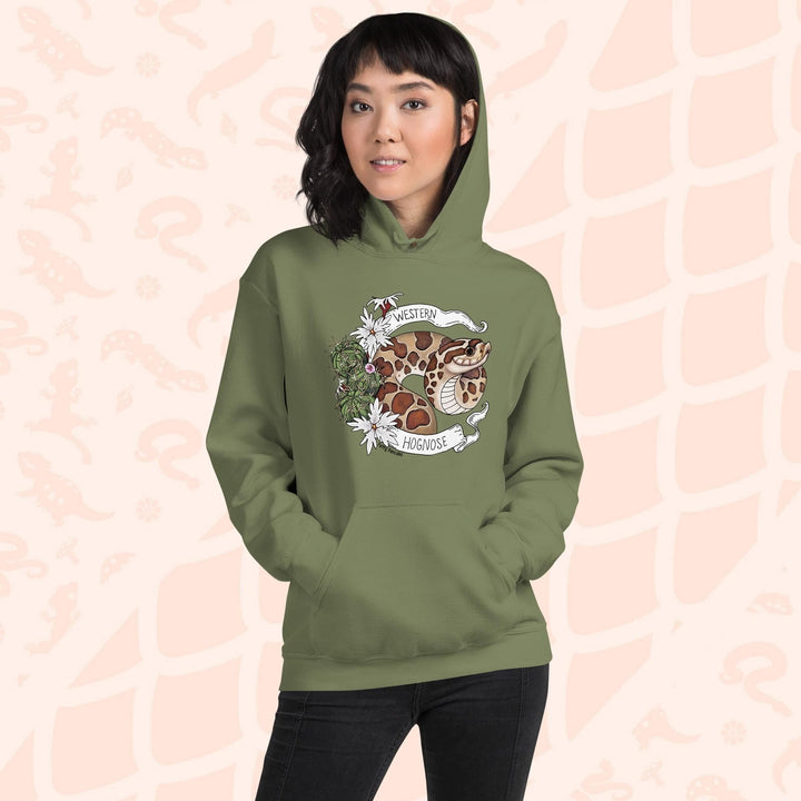 A woman wearing an olive green colored hoodie with a line art with color hognose snake surrounded by a white banner with text that reads "Western Hognose". Cactus and white flowers are on the left side of the design.