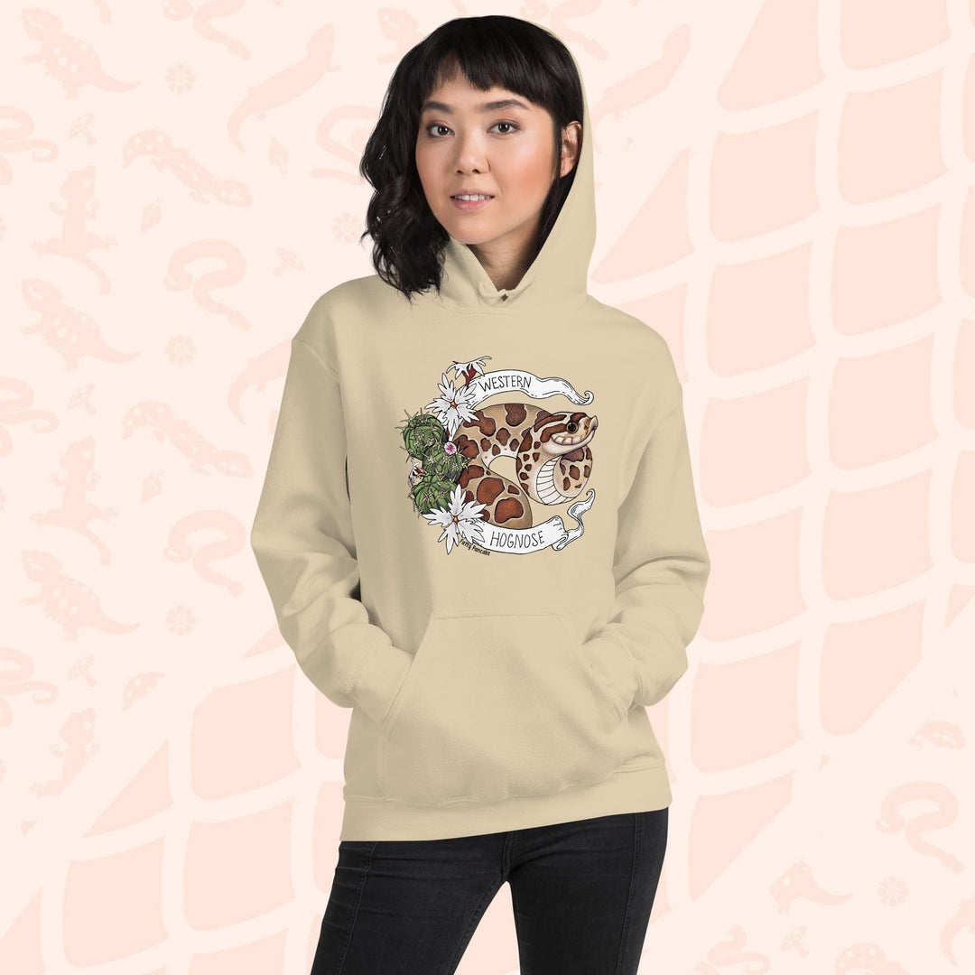 A woman wearing an cream colored hoodie with a line art with color hognose snake surrounded by a white banner with text that reads "Western Hognose". Cactus and white flowers are on the left side of the design.
