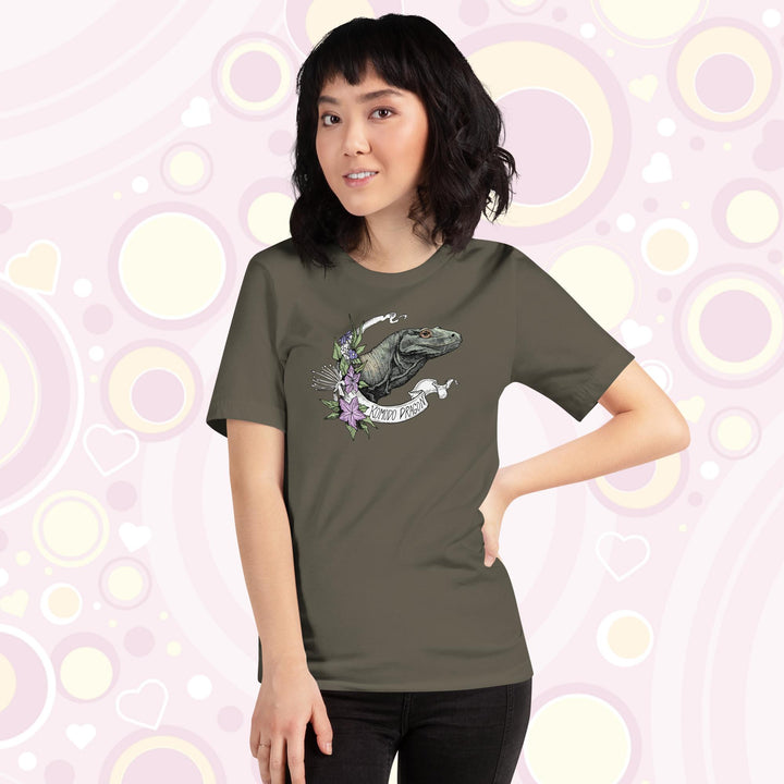 Woman wearing army colored crew neck tee with a head shot of a komodo dragon lizard framed by purple flowers and a white banner with text of the animal name.