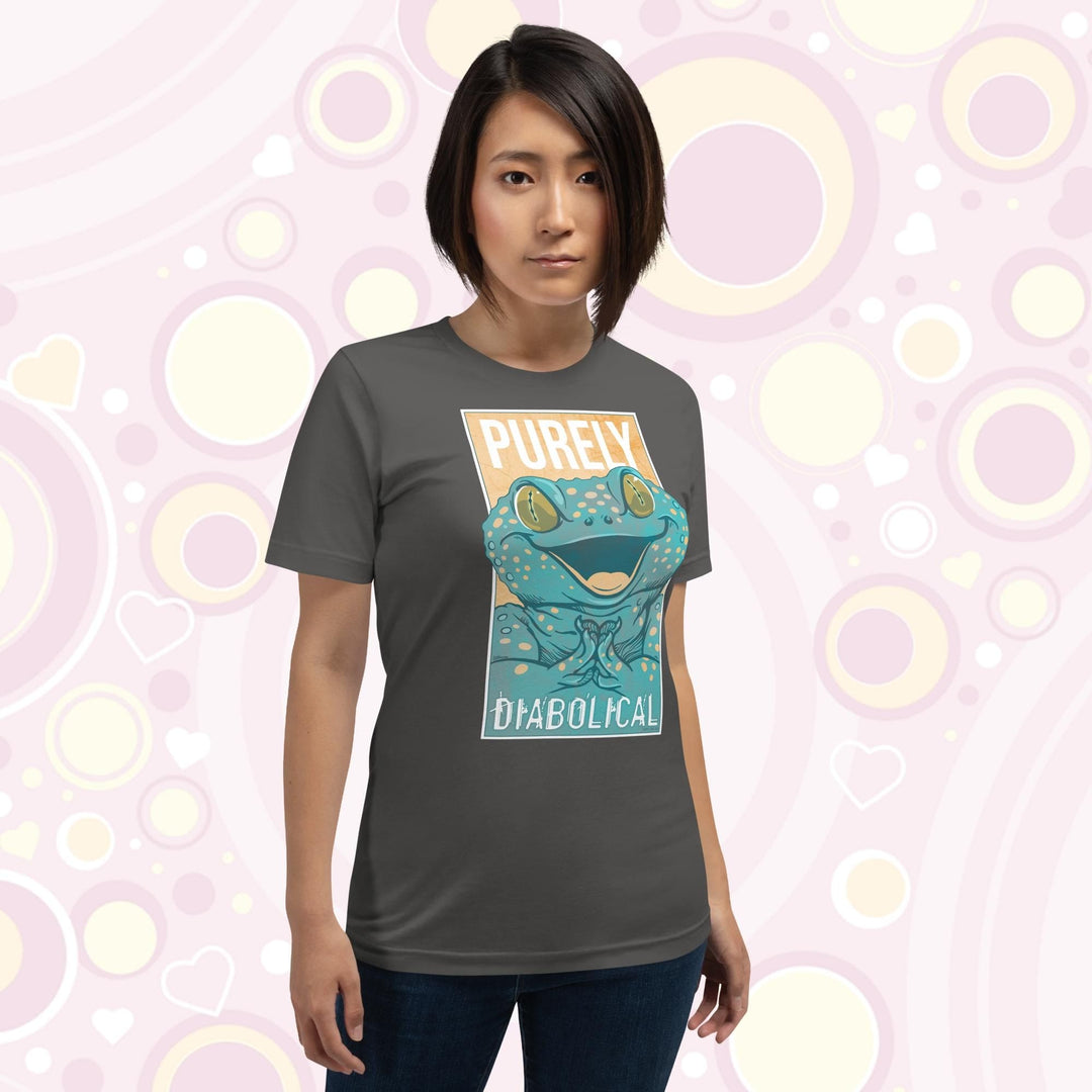 A woman wearing an asphalt grey colored crew neck tee with a large mischievous looking Tokay Gecko smiling and pressing it's feet together. The text Purely Diabolical is split above and below the gecko art.