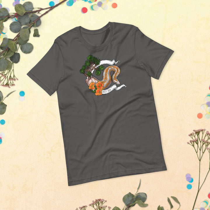 Image depicts a flat lay of a grey shirt with the rosy boa graphic on the front. Leaves and plants are framing around the tee that sits in the center of the image.