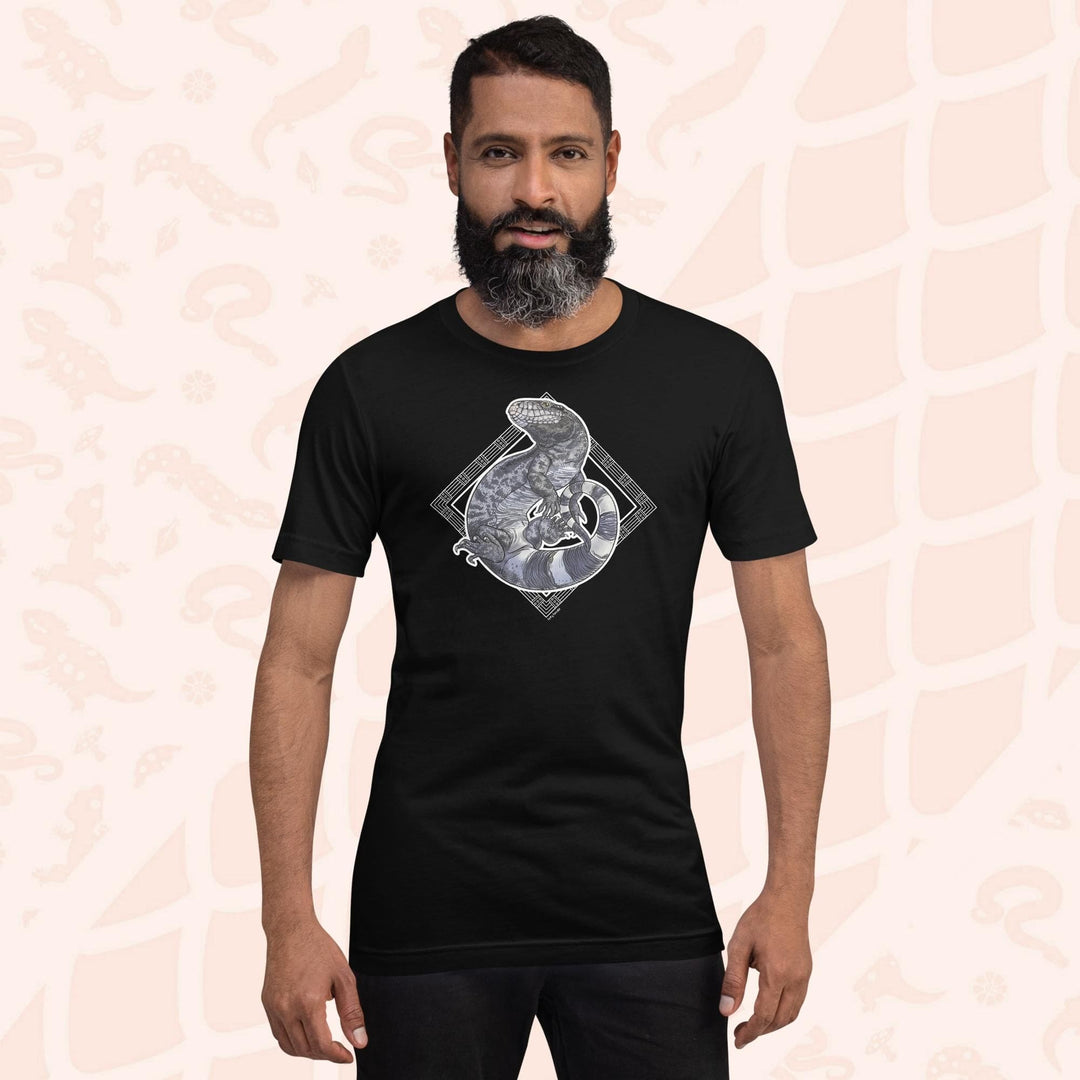 Man wearing a black colored unisex crew neck tee with a graphic of a black and white tegu curled up in a graphic element.