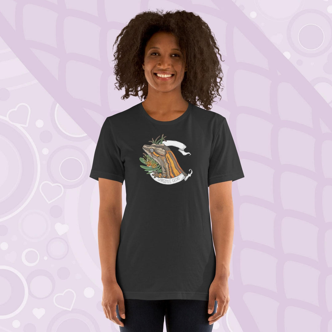A woman wearing a dark grey colored crew neck shirt with an orange striped gargoyle gecko graphic in the middle of the shirt. 