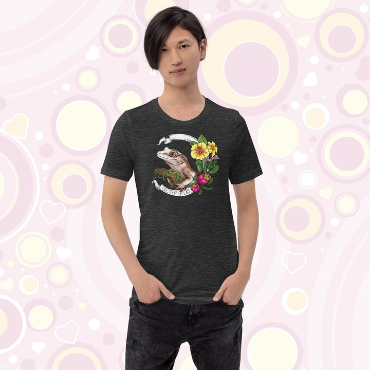 A teen wearing a grey crew neck tee of a crested gecko holding a branch with yellow hibiscus and other pink flowers as accents along the right of the design. A circular banner reads the name of the animal species on it.