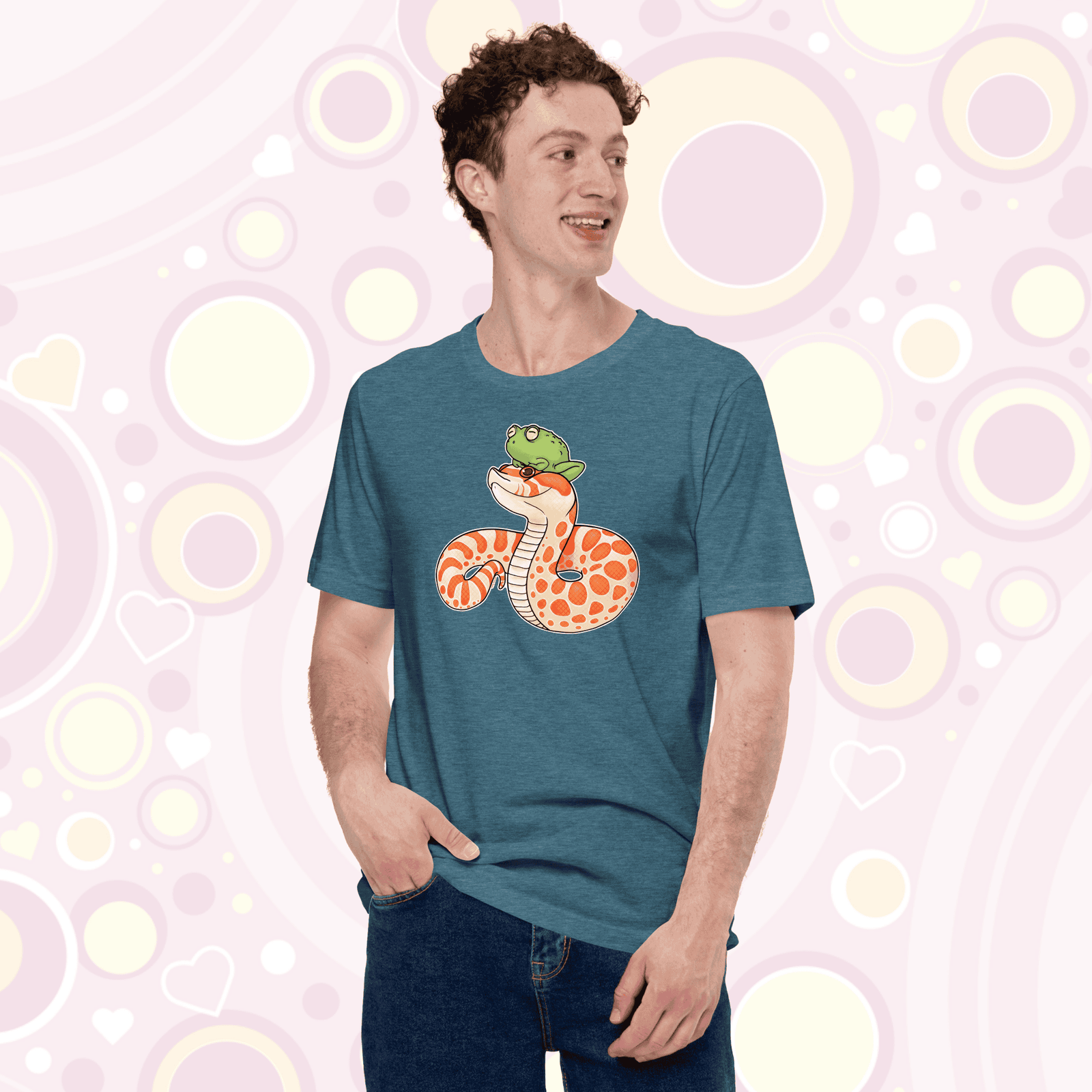 A man wearing a heather deep teal crew neck tee with a cartoon albino hognose snake with a frog perched on it's head.
