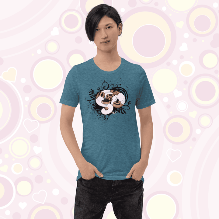 Young adult wearing heather teal colored crew neck tee with a pied ball python graphic with simple black swirls, leaves, and spatter marks behind it.