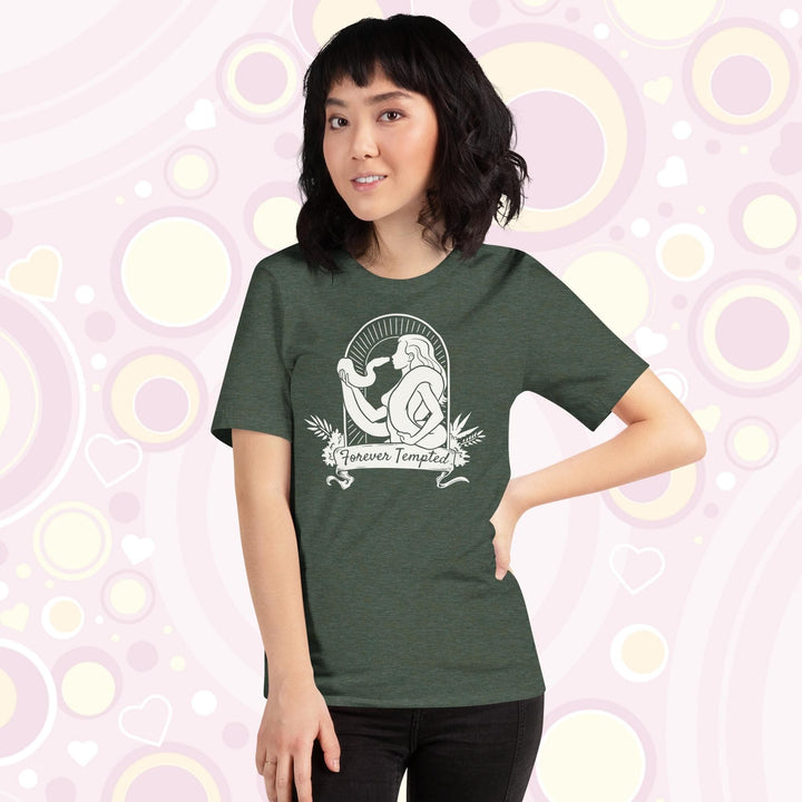 A lady wearing a heather forest green crew neck tee with a silhouette of a woman holding a snake and text saying "Forever Tempted".