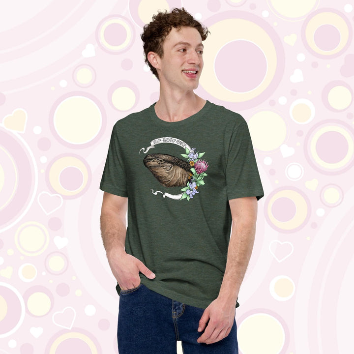 Man wearing a heather green colored crew neck tee of a black throated monitor encircled by a banner that reads the species name and with rendered blue and red flowers next to it.