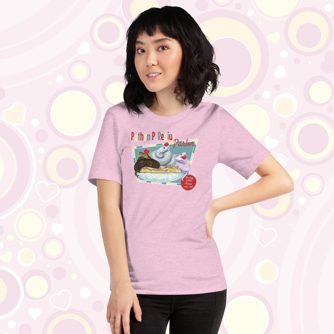 Lady wearing a light lilac crew neck tee showing a retro style design of 4 ball pythons in a banana split boat; one representing chocolate, strawberry, and vanilla ice cream and each topped with a sweet cherry! The text Python P Regius is on top in multi colors.